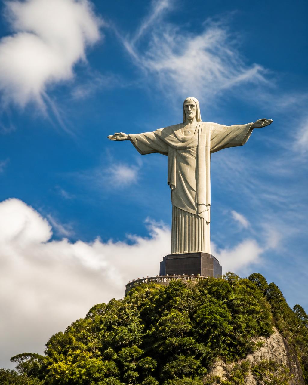 Visitantes de braços abertos diante do Cristo Redentor